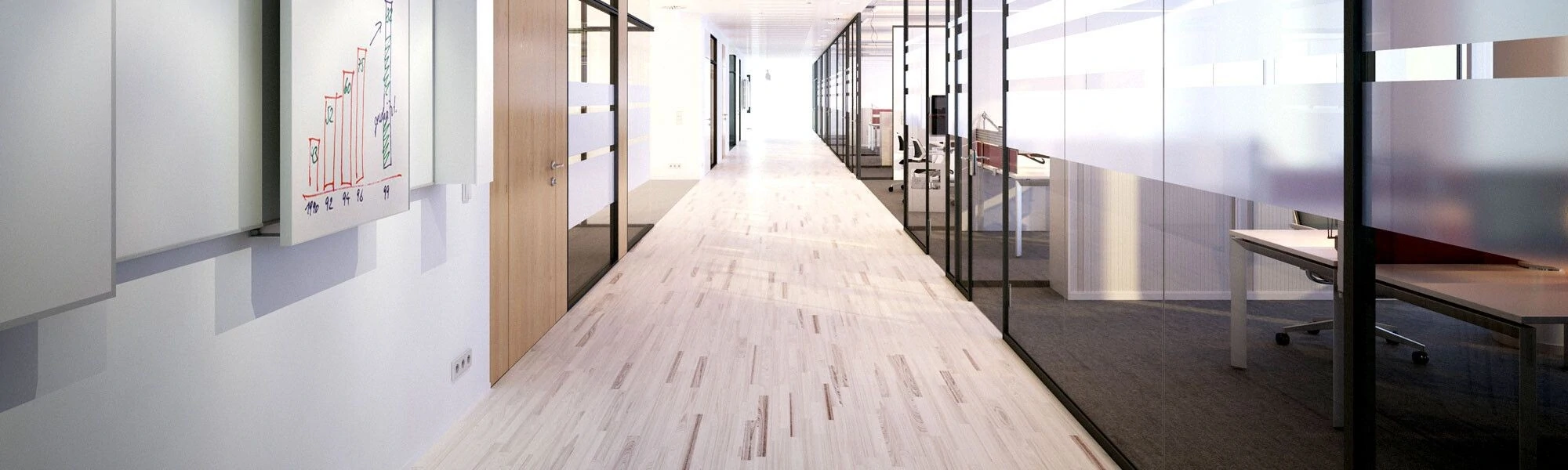 Modern office hallway featuring glass-walled meeting rooms